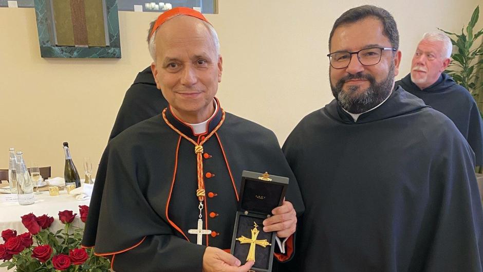 El entonces cardenal Prevost recibe la cruz del padre Josef Sciberras