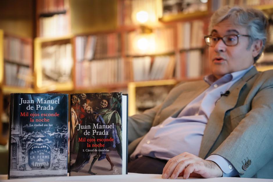 El escritor junto con las dos entregas de su novela 'Mil ojos esconde la noche'