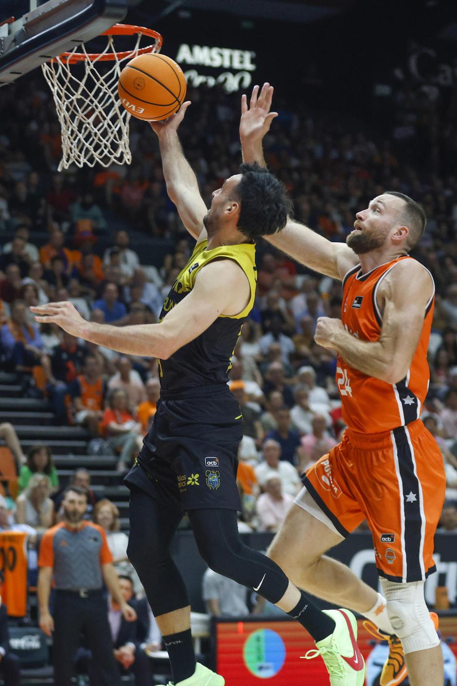 El base de La Laguna Tenerife Lluís Costa (i) entra a canasta defendido por Matt Costello, del Valencia Basket, durante el segundo partido de la semifinal