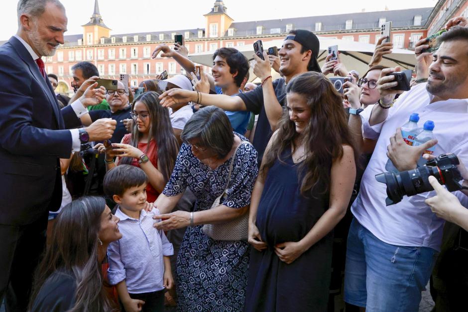 Un grupo de jóvenes fotografía al Rey mientras otros le saludan