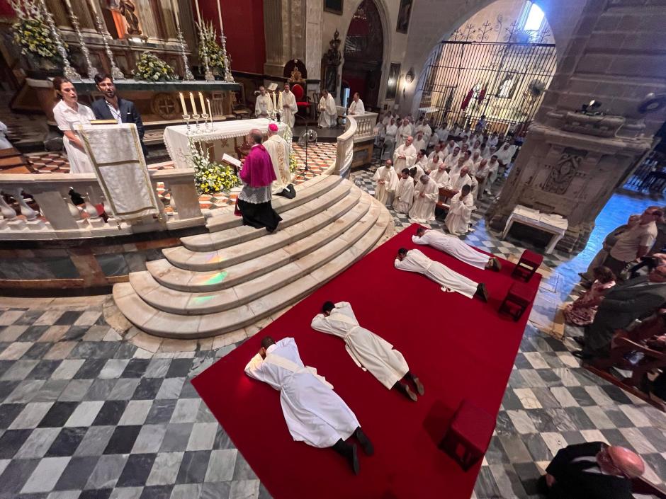 Los cuatro jesuitas, postrados durante la celebración