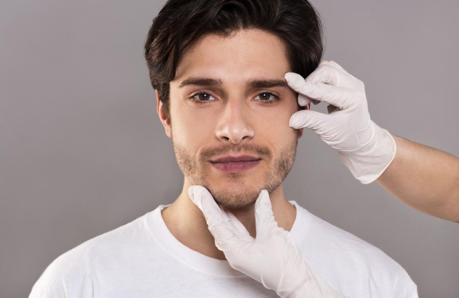 Facial massage, wrinkles prevention. Beautician massaging her face of young handsome man