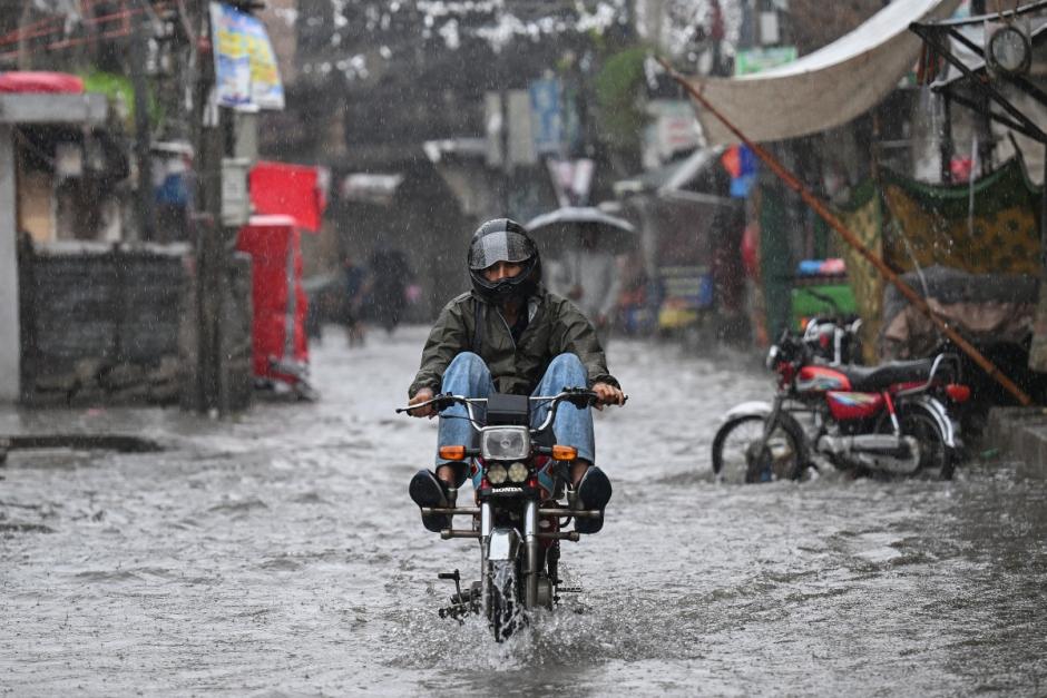 A man on a motorbike wades through a flooded street during heavy monsoon rains in Rawalpindi on July 17, 2025. Monsoon rains in Pakistan have been linked to more than 110 deaths including dozens of children since they arrived in late June, according to government figures released on July 14. (Photo by Aamir QURESHI / AFP)