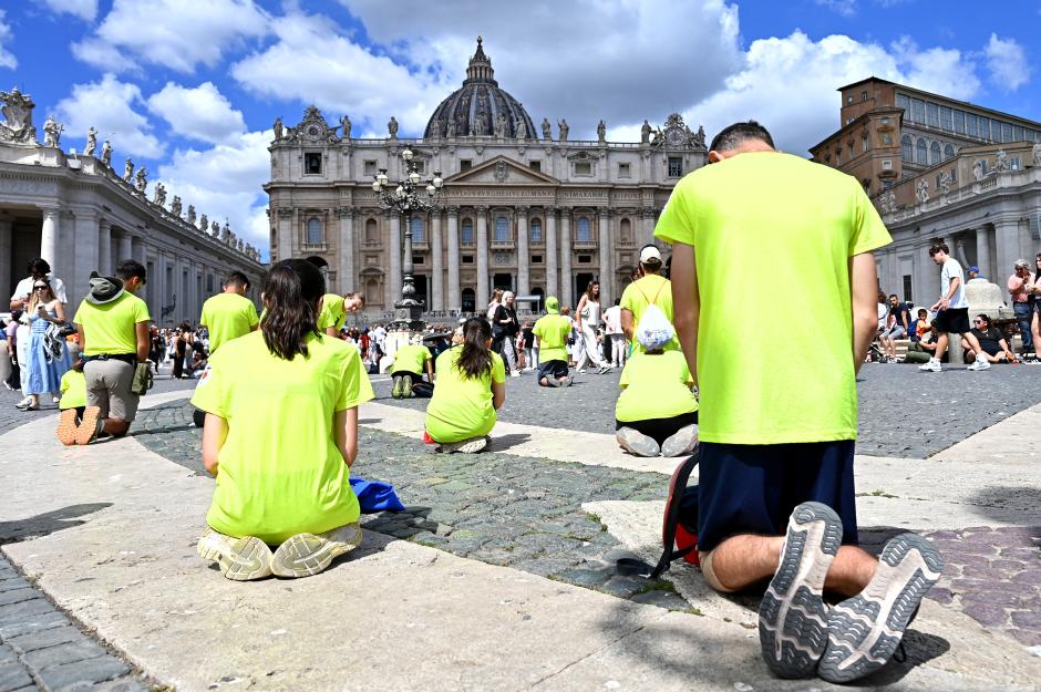 People pray as Pope Leo XIV addresses the crowd from the window of the Apostolic Palace overlooking St. Peter's square during his Angelus prayer at the Vatican on July 26, 2025. (Photo by Alberto PIZZOLI / AFP)
