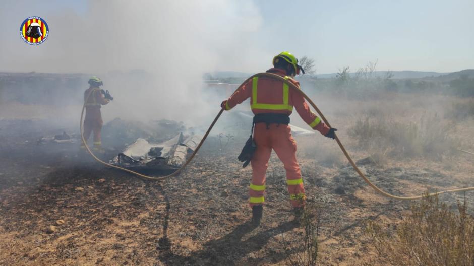 Imagen de los bomberos apagando el fuego provocado en el accidente de avioneta en Requena, Valencia