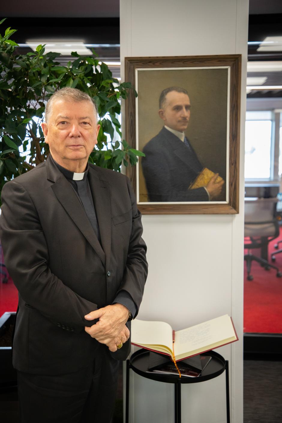 Monseñor Martínez Camino posa junto al retrato de Herrera Oria