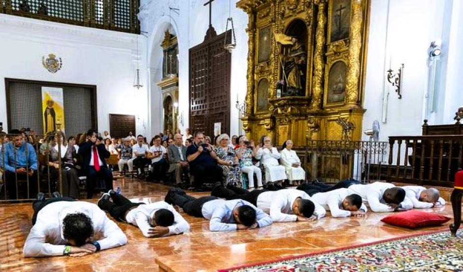 Los siete jóvenes, postrados en el suelo del presbiterio antes de recibir su nuevo uniforme