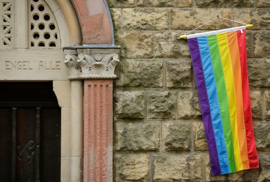Una bandera arcoíris se ve en la pared de una iglesia católica en Colonia, Alemania, el 10 de mayo de 2021, mientras el edificio está abierto para que las parejas del mismo sexo reciban la bendición