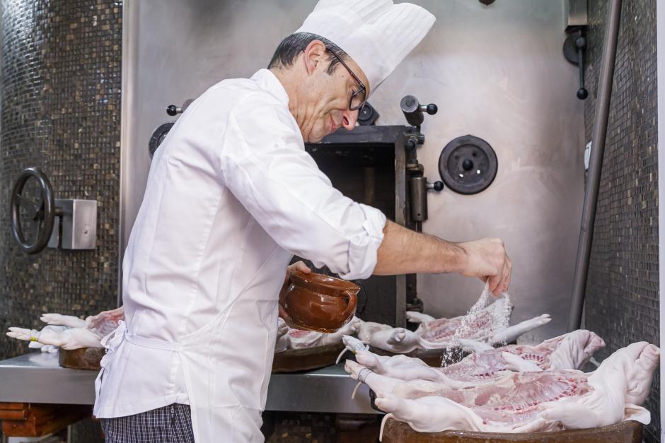 Un cocinero prepara un cochinillo de Segovia, uno de los manjares de la cocina castellana