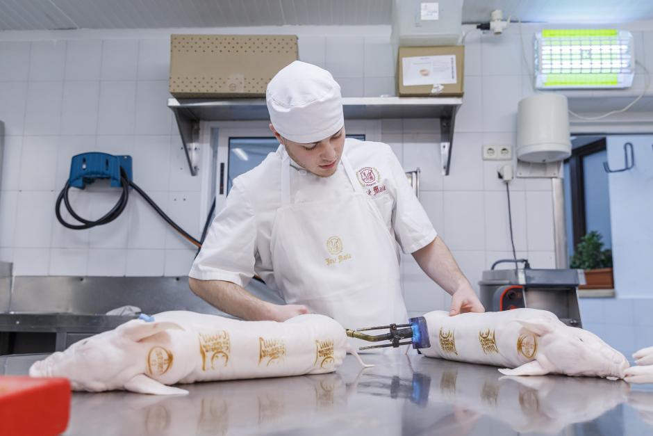 Un cocinero marca cochinillos segovianos con su sello de garantía