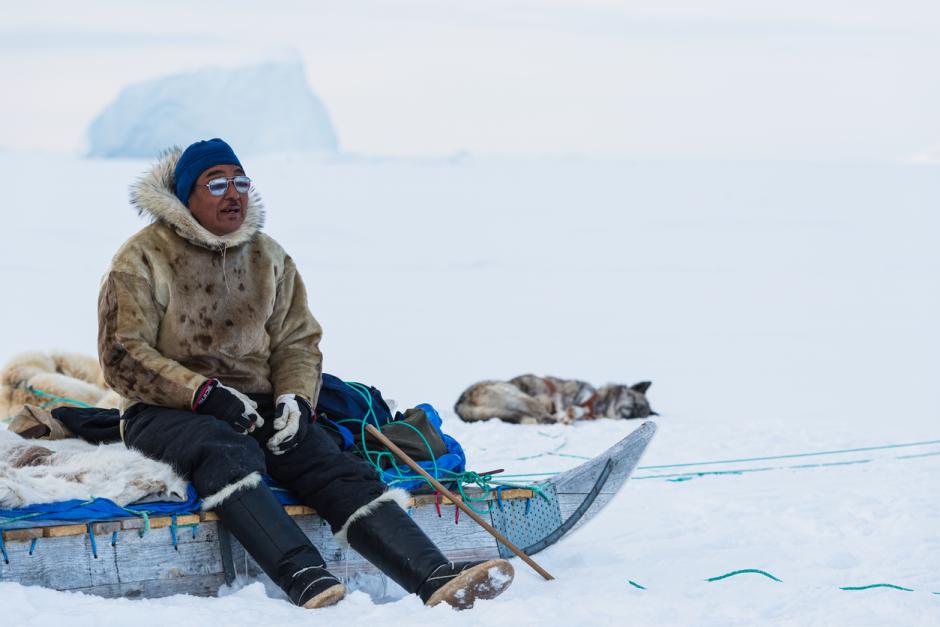 Un hombre inuit descansa en su trineo