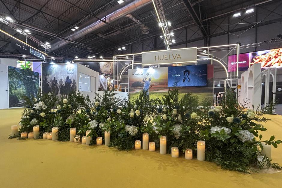 Flores y velas ante el estand de Huelva en la Feria Internacional del Turismo (Fitur)
