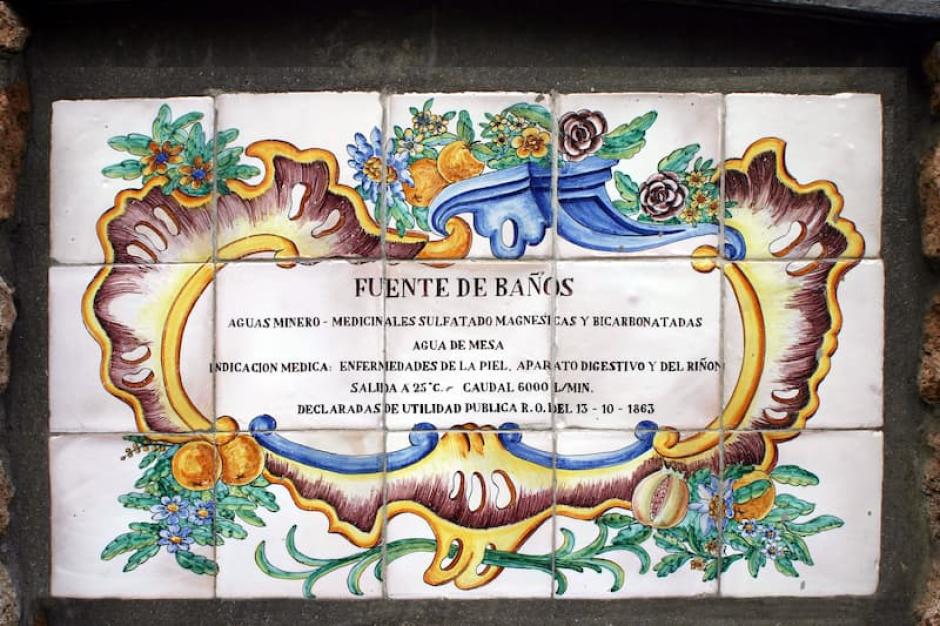 Cartel antiguo que informa sobre las propiedades de la Fuente de los Baños