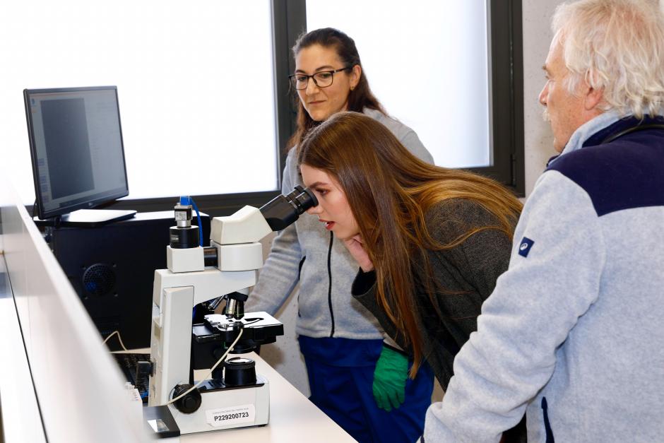Doña Sofía observa por el microscopio en el laboratorio del complejo de la ONCE
