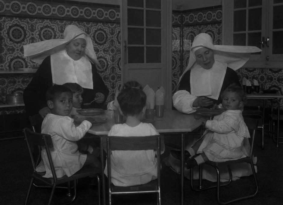 Dos hermanas de la Caridad atienden a niños huérfanos en Madrid en 1932