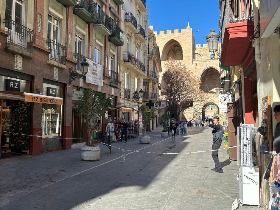 Imagen de un agente de la Policía Local cortando la calle Serranos por desperfectos ocasionados por el viento.