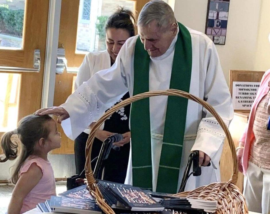 El padre Turro bendice a una niña de su parroquia
