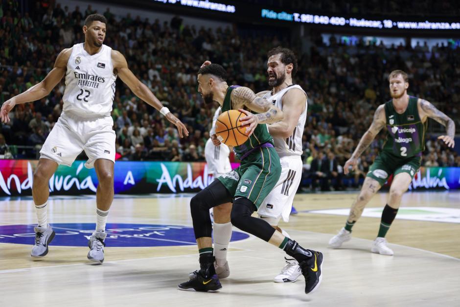 El alero del Unicaja Chris Duarte (2i) intenta superar a Sergio Llull,