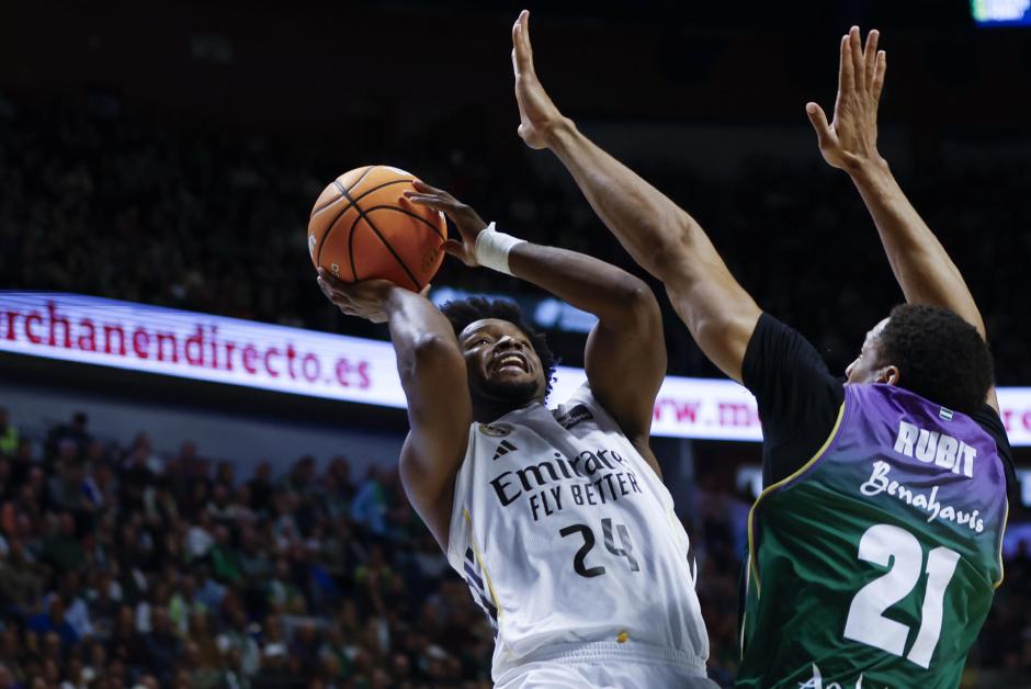 El base dominicano del Real Madrid Andrés Feliz (i) lanza a canasta ante Augustine Rubit