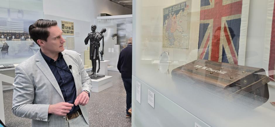 Un guía muestra el mapa de la partición de Alemania en zonas de ocupación y un cofre con las iniciales del primer ministro británico Winston Churchill junto a otros objetos y fotografías de la Cumbre de Yalta