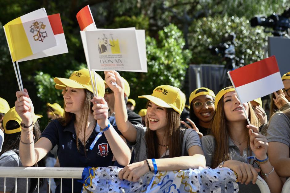 Jóvenes y catecúmenos esperan la llegada del papa León XIV frente a la iglesia de Sainte-Devote en Montecarlo
