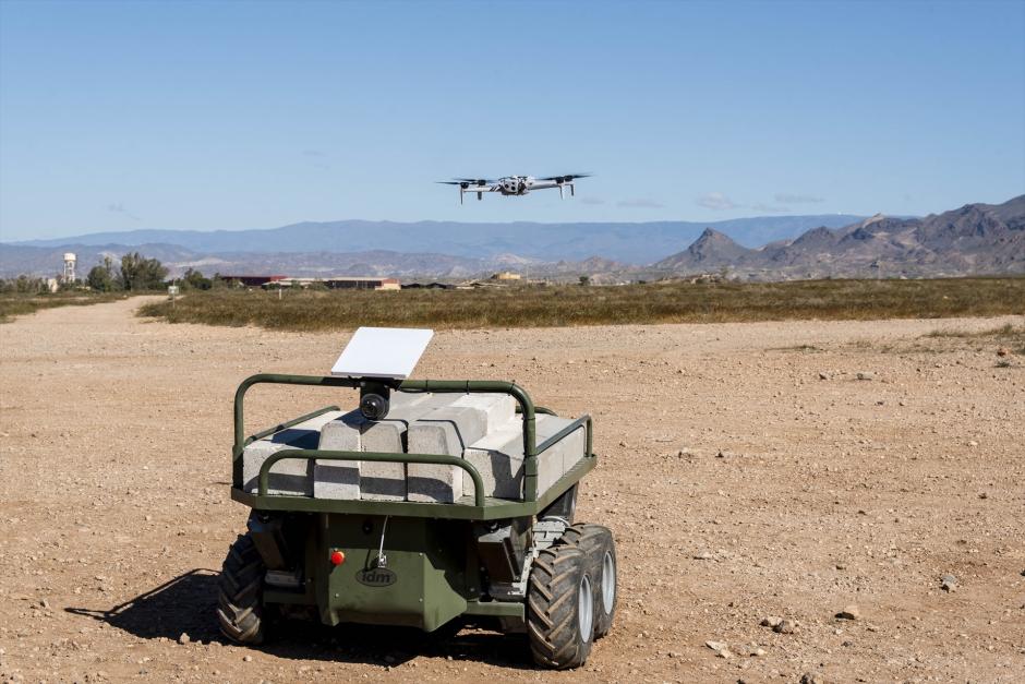 Un vehículo no tripulado para transportar material y un dron en vuelo, durante la Campaña de Experimentación Táctica de Viator