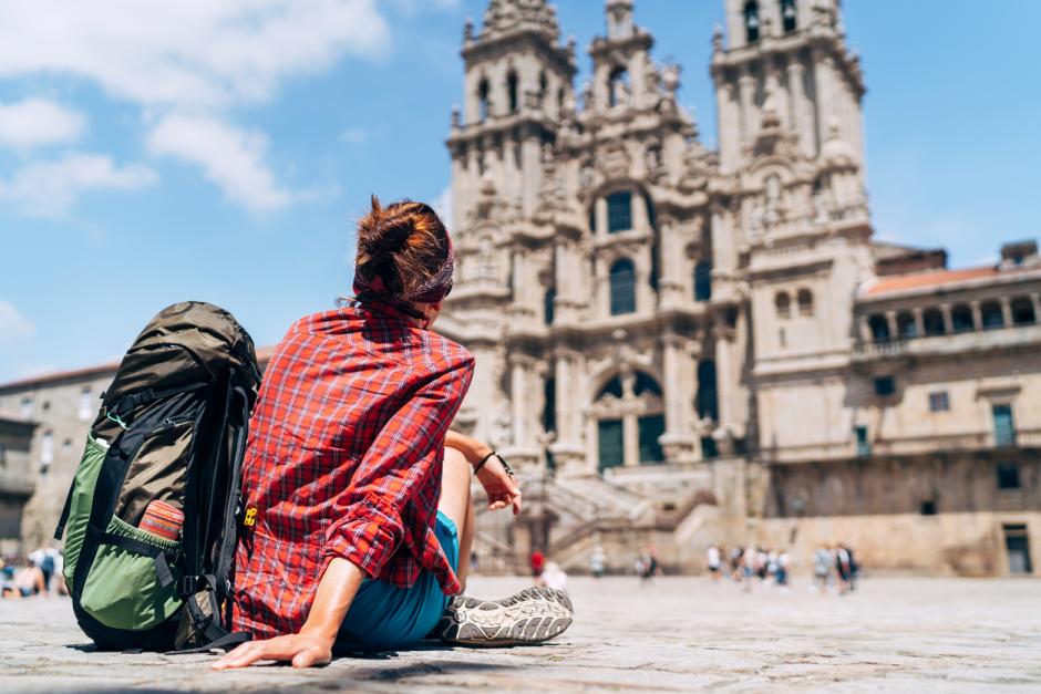 Una peregrina contempla la catedral de Santiago desde la plaza del Obradeiro