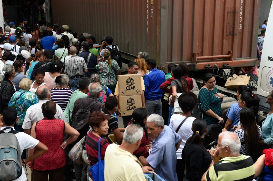 Employees of the University Hospital queue to receive boxes with basic goods provided by the government program "CLAP" (Local Committees for Supply and Production), outside the hospital, in Caracas on June 26, 2018. Venezuelan President Nicolas Maduro's socialist government is in the midst of an ever-deepening crisis with food and medicine in short supply. (Photo by Federico PARRA / AFP)