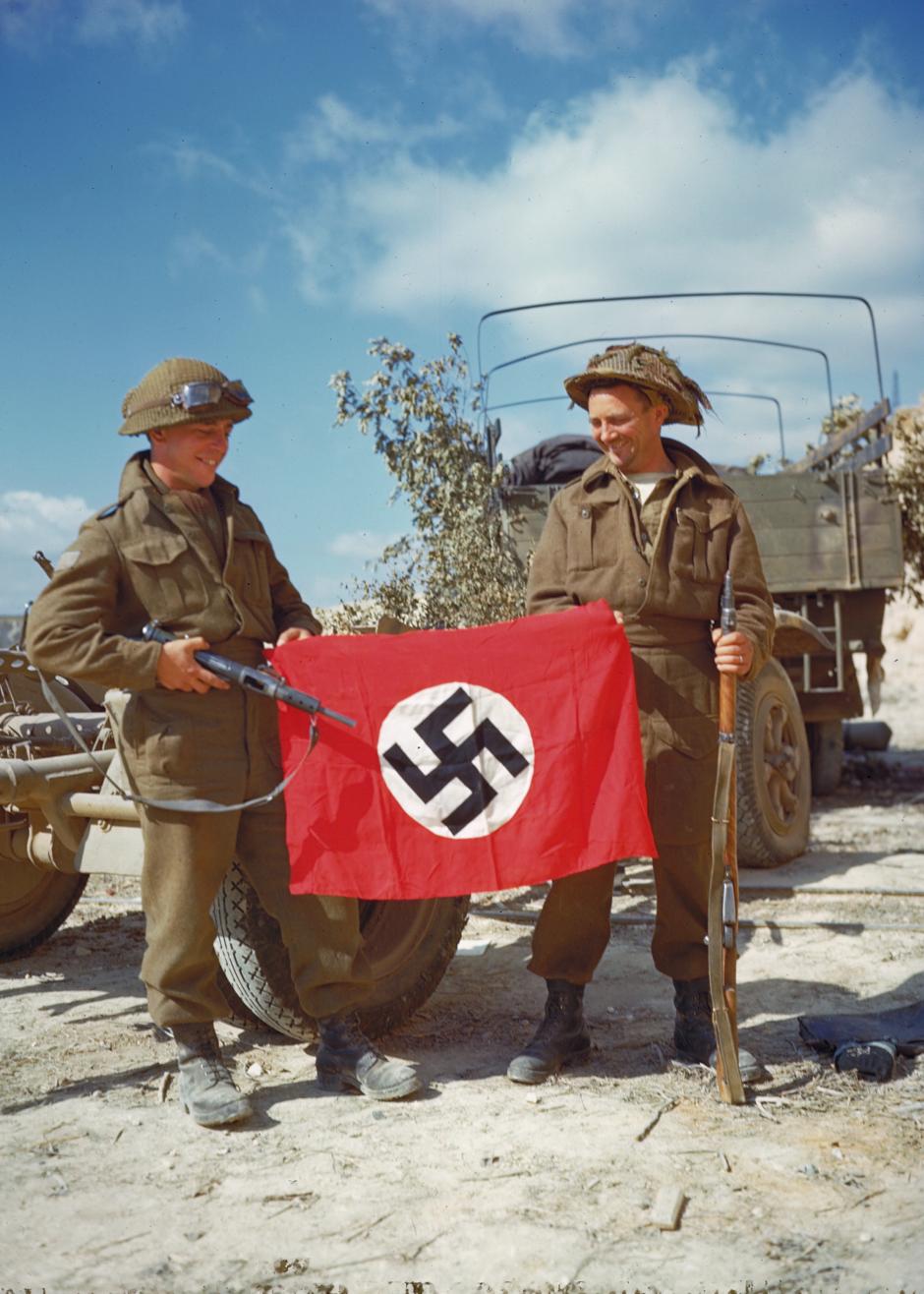 Soldados canadienses con una bandera nazi capturada