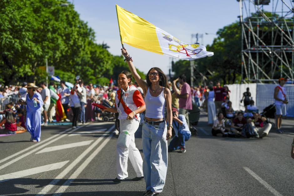 Una joven porta una bandera de El Vaticano en los alrededores de la Plaza de Lima. En el fondo una voluntaria