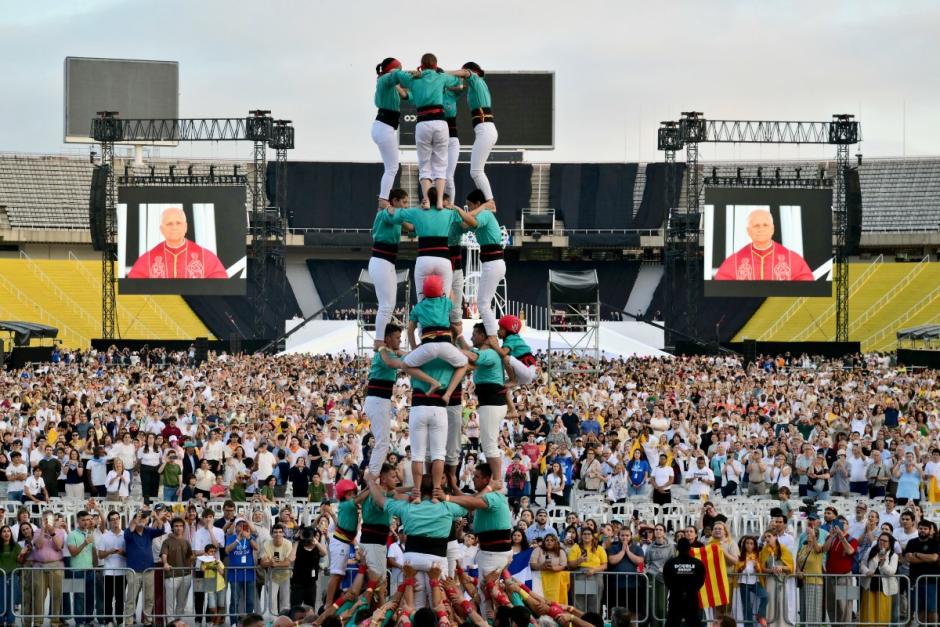 Pope Leo XIV is seen in a giant screen next to a Catalan human tower as he arrives to attend a prayer vigil at the Lluis Companys Olympic Stadium in Barcelona, on June 9, 2026. Pope Leo XIV is visiting Spain June 6-12 with stops in Madrid, Barcelona, and the Canary Islands, where he will meet with migrants and organisations dedicated to helping them. (Photo by Stefano RELLANDINI / AFP)