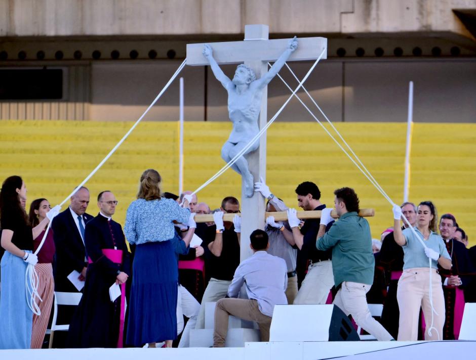 Volunteers lift the Christ on the Cross during a prayer vigil at the Lluis Companys Olympic Stadium in Barcelona, on June 9, 2026. Pope Leo XIV is visiting Spain June 6-12 with stops in Madrid, Barcelona, and the Canary Islands, where he will meet with migrants and organisations dedicated to helping them. (Photo by Stefano RELLANDINI / AFP)