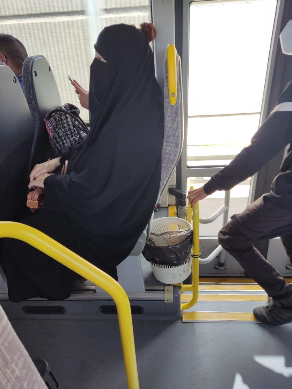 Mujer cubierta por un niqab en un autobús