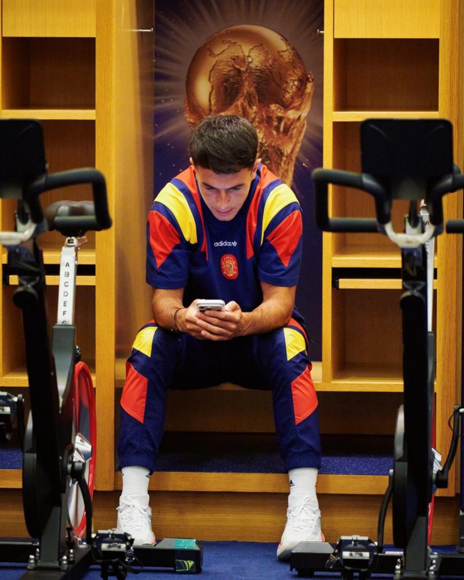 Zubimendi se distrae con el móvil junto a las bicicletas estáticas del vestuario de la selección.