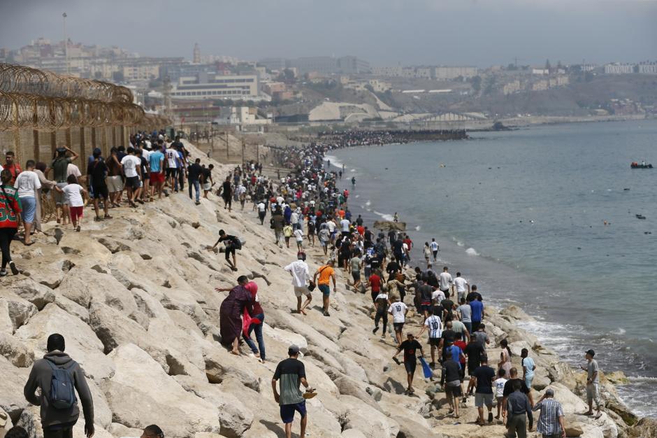 Imagen de la avalancha de inmigrantes llegando al espigón desde el lado marroquí