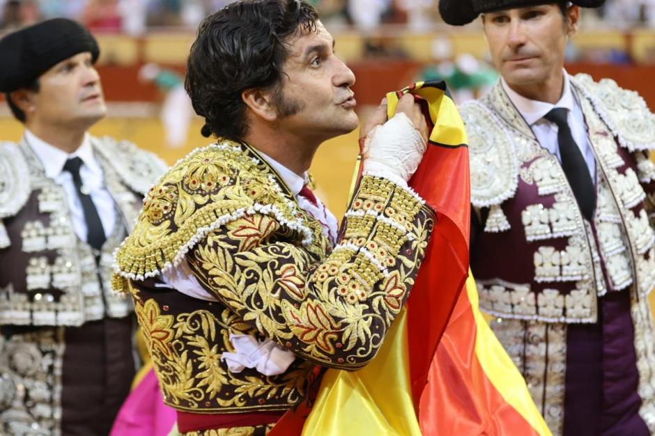 Morante de la Puebla besa una bandera recogida con su mano maltrecha tras el percance sufrido en Palma de Mallorca