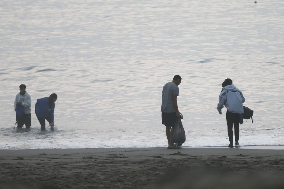 Algunas personas en la playa tras entrar a Ceuta a través del espigón del Tarajal