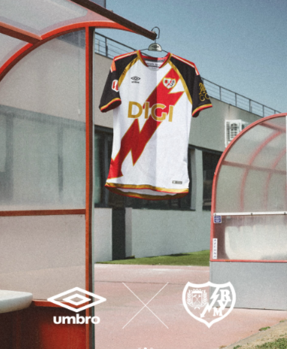 La camiseta apuesta por el característico rayo como elemento central del diseño, combinado con detalles en rojo y dorado que realzan la identidad del Rayo Vallecano.