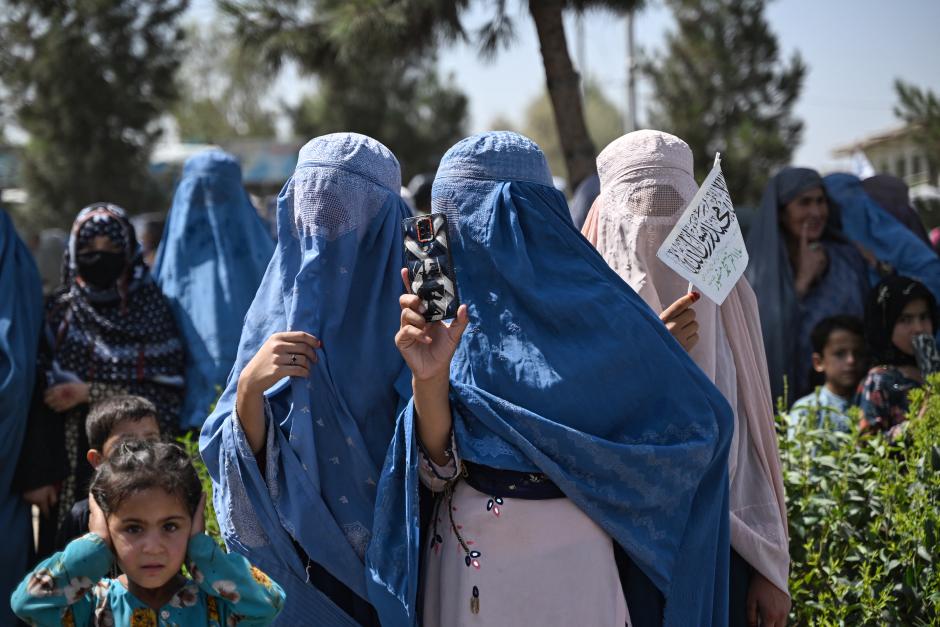 Mujeres afganas graban con sus móviles la celebración de los talibanes en una calle de Kandahar