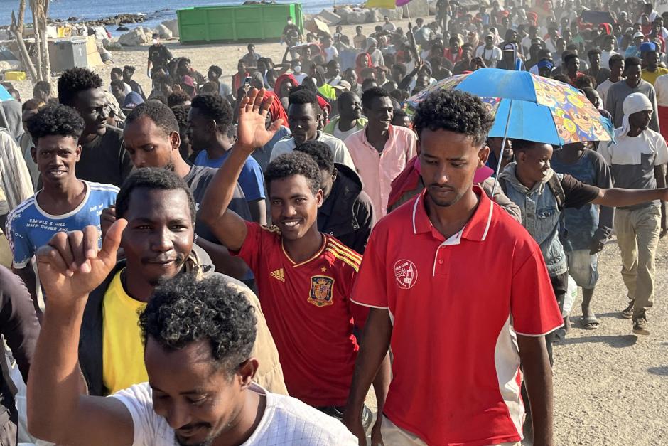 Inmigrantes desalojados de la playa del Trampolín en Ceuta tras habilitarse un espacio para su acogida este jueves