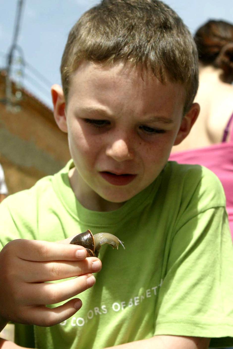 Uno de los niños muestra su caracol momentos antes de la carrera