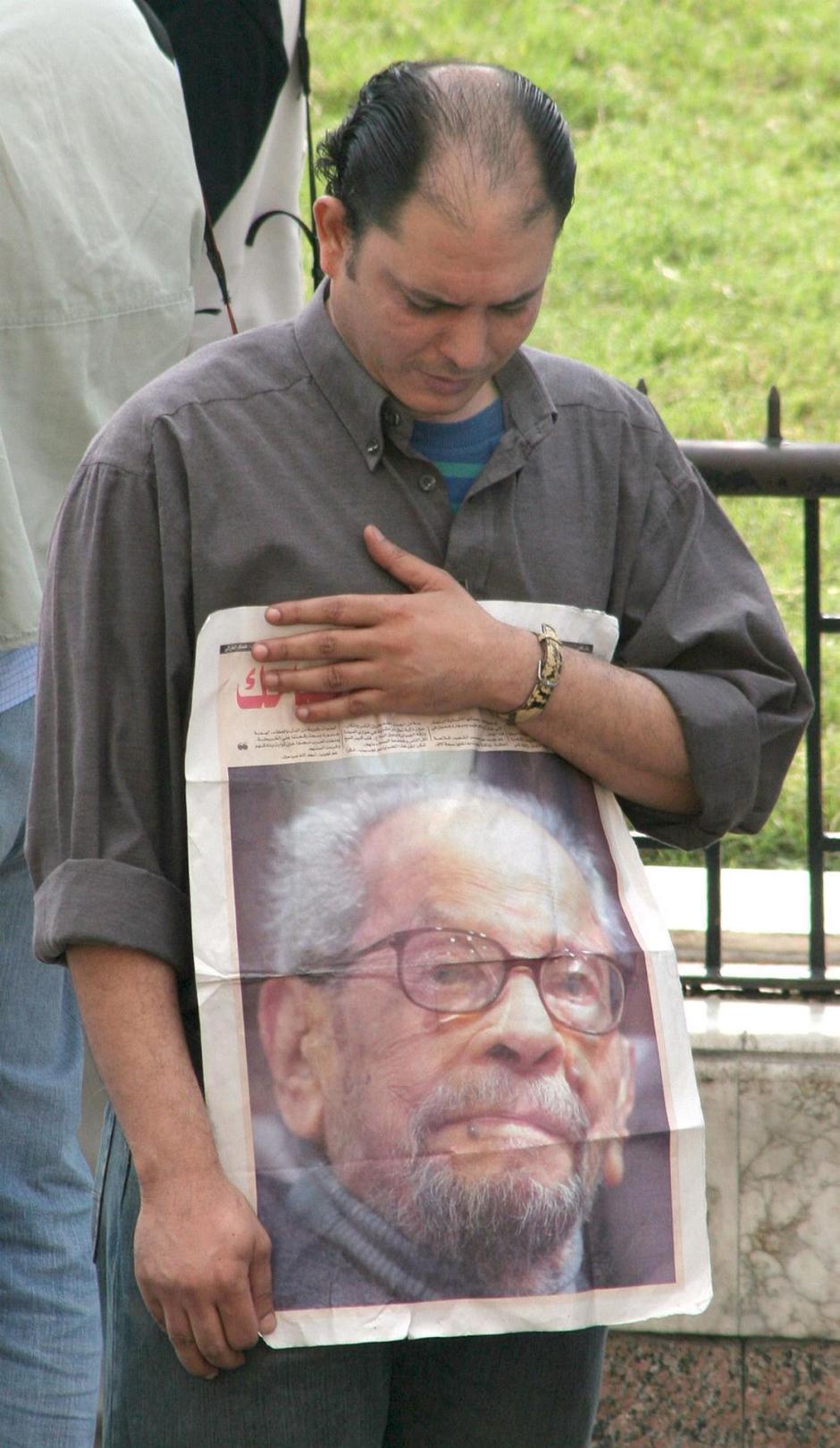 Un hombre sujeta un retrato de Naguib frente a la mezquita de Al Hussein en El Cairo,