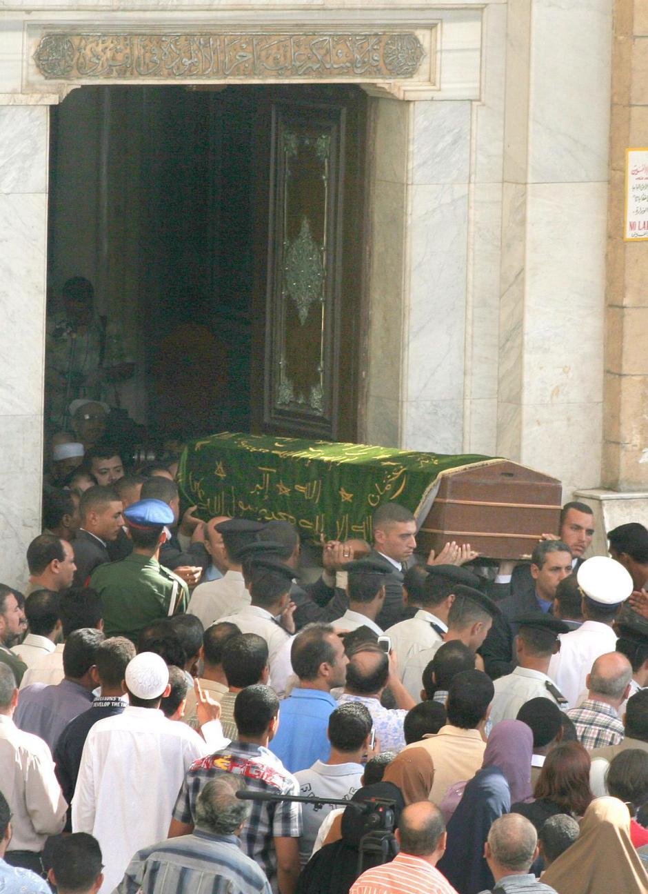 Varios hombres trasladan el ataud de Naguib Mahfuz cubierto con una bandera islámica en la mezquita de Al Hussein en El Cairo