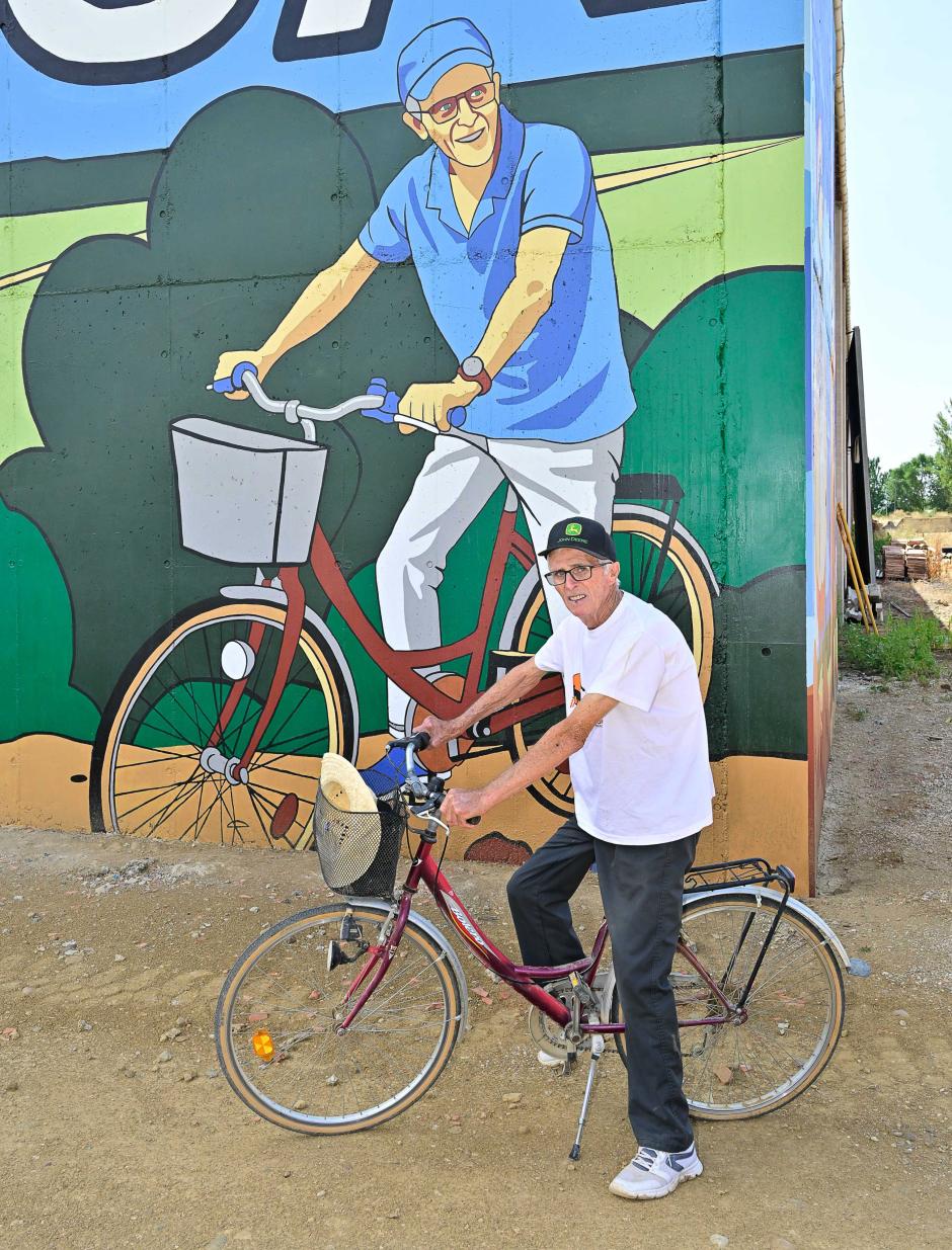Un vecino de Polvorosa posa junto a su retrato en grafiti