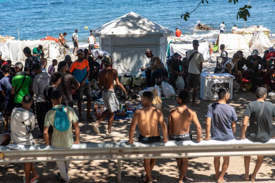 Un grupo de inmigrantes se reúne junto a tiendas de campaña improvisadas