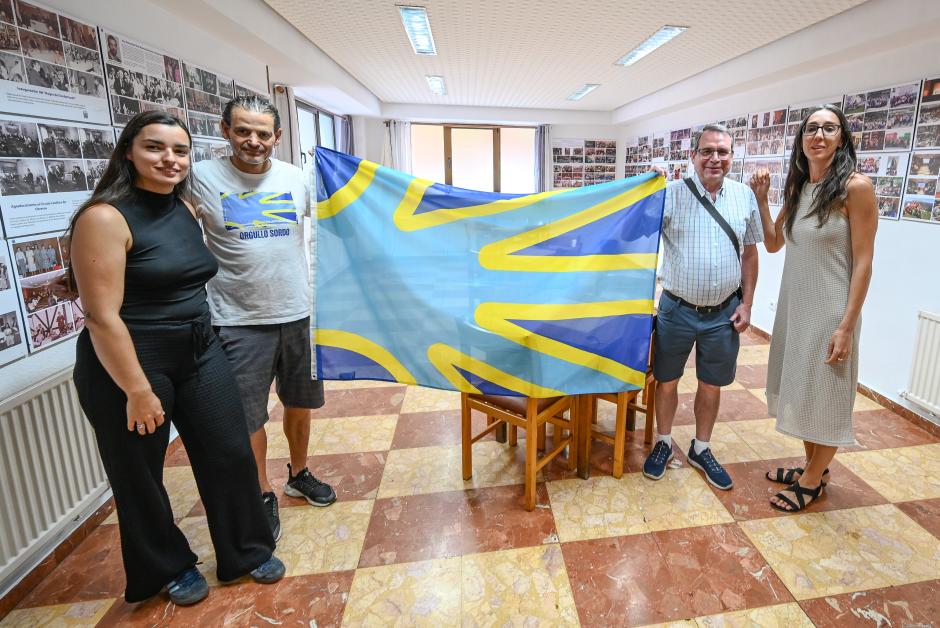 Los miembros de la Asociación de Personas Sordas Fray Pedro Ponce de León posan con la bandera de la lengua de signos