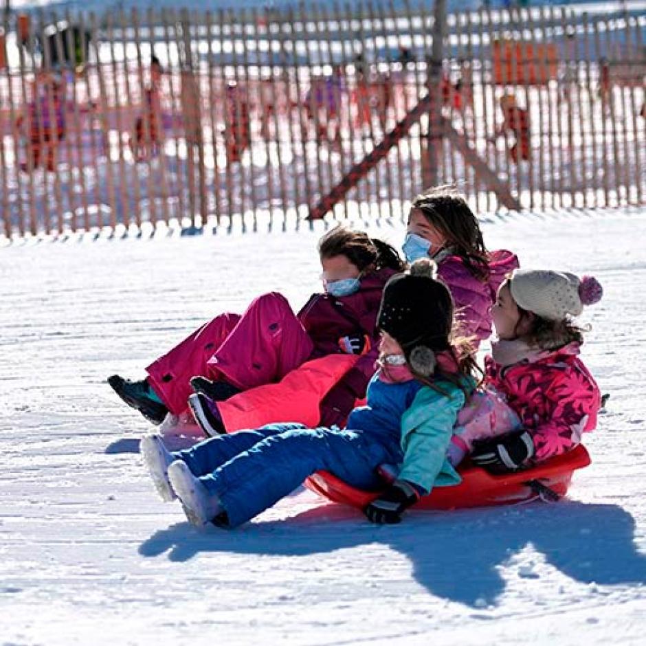 Niños con trineo en el parque de nieve de La Covatilla
