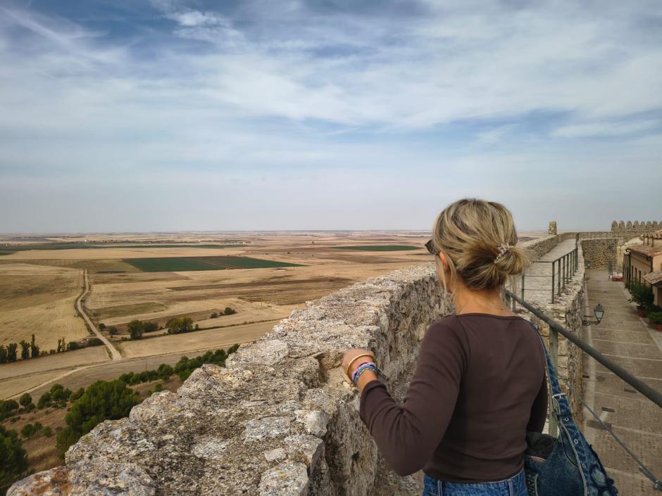 Una turista contempla la comarca de Tierra de Campos desde lo alto de la muralla de Urueña, en Valladolid