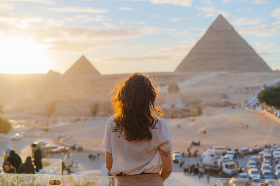 Mujer viajera frente a las pirámides de Giza, en El Cairo (Egipto)
