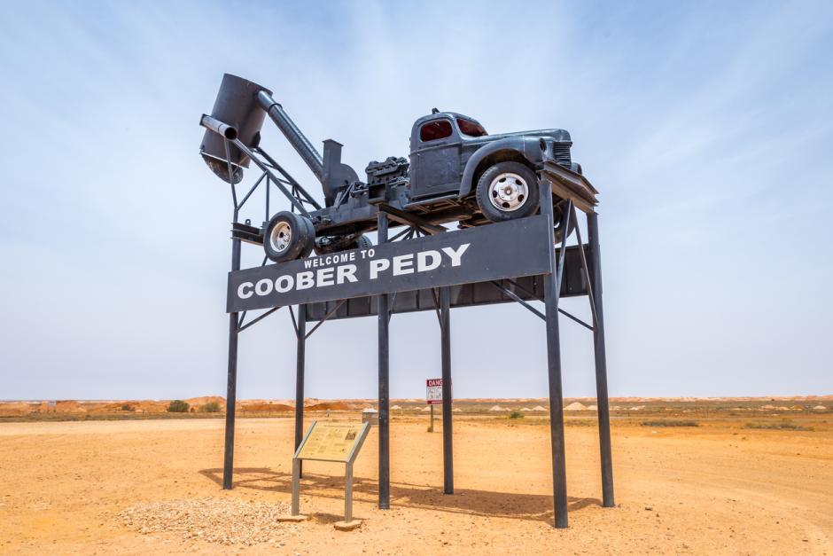 Cartel de bienvenida a Coober Pedy con un viejo camión minero